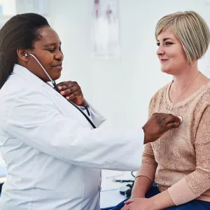 A patient having her heart listened to.