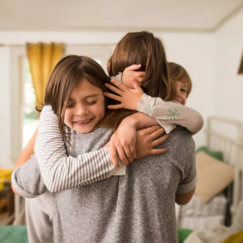 A mom getting warmed hugs from her kids.